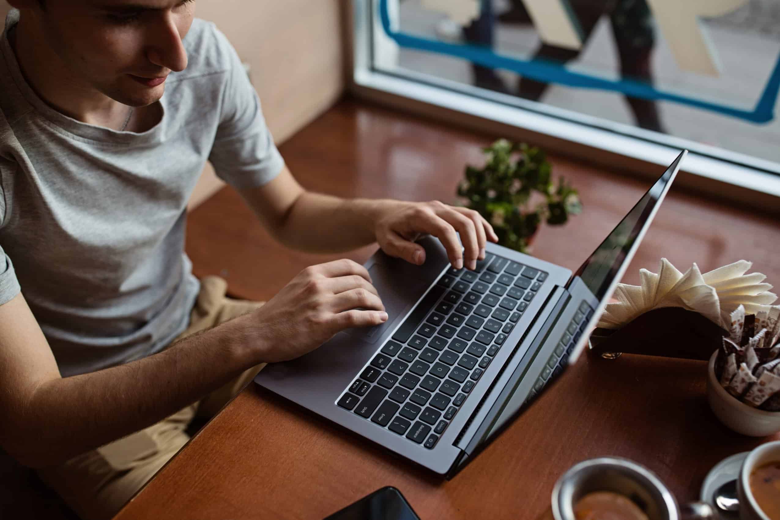 Man using laptop in a cafe