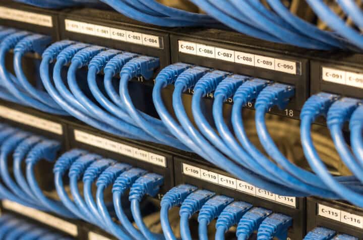 rows of network cable connected to router and switch in server room